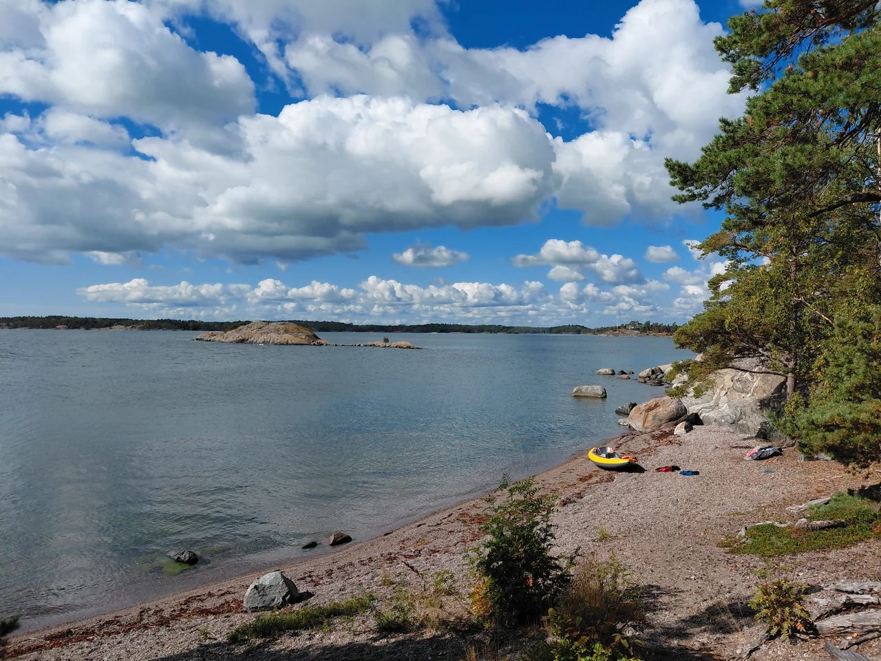 Petite plage rocheuse et kayak jaune face aux îles de l’archipel de Stockholm