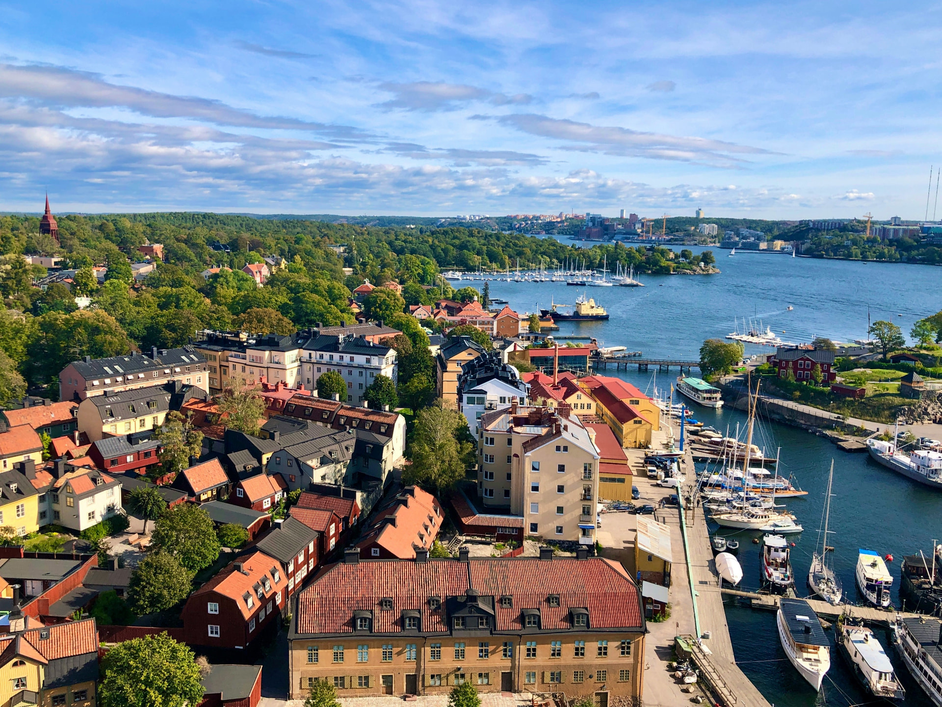 Toits colorés et port de Stockholm vus du ciel en été, avec l’archipel en arrière-plan